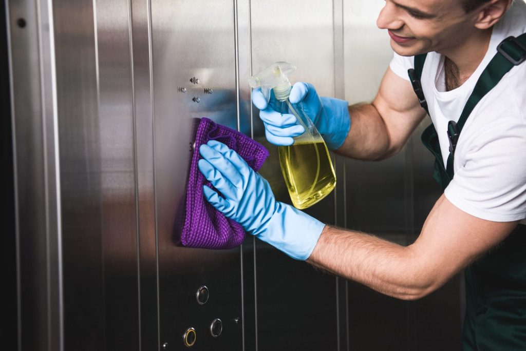 Kamloops janitorial services - man cleaning silver wall panel.