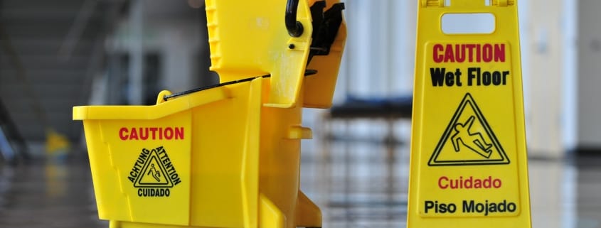 kelowna janitorial services yellow safety sign, mop and bucket on floor
